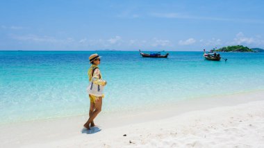 Koh Lipe Adası Güney Tayland Turkuaz renkli okyanusları ve Ko Lipe 'de beyaz kumlu plajları var. Tayland 'da tatilde olan Asyalı bir kadın sahilde yürüyor.