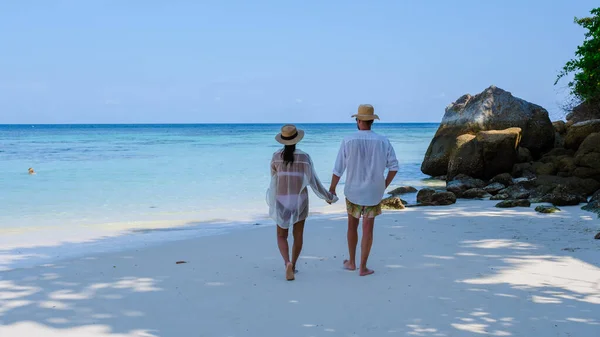 タイ南部のコリペ島では ターコイズ色の海と白い砂浜があります タイで休暇中の男女がビーチを歩いていて — ストック写真