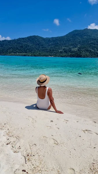 タイ南部のコリペ島では ターコイズ色の海と白い砂浜があります タイで休暇中の女性がビーチを歩いていて — ストック写真