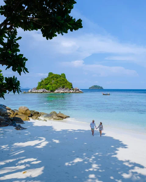 タイ南部のコリペ島では ターコイズ色の海と白い砂浜があります タイで休暇中の男女のカップルが — ストック写真