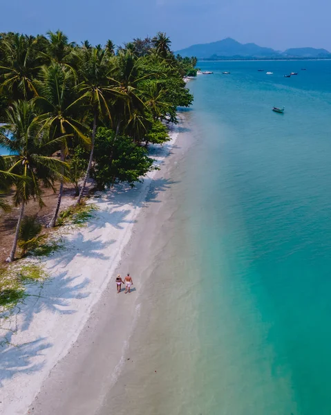 タイのアンダマン海にあるコ ムック熱帯の島で休暇中の男性と女性のカップル ヤシの木があるビーチを歩く男性と女性ドローンの空中ビュー — ストック写真
