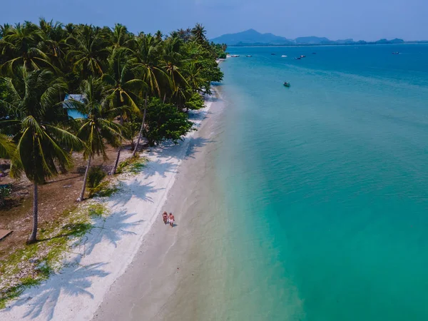 タイのアンダマン海にあるコ ムック熱帯島で休暇中の男性と女性のカップル 晴れた日にヤシの木とビーチを歩く男性と女性 — ストック写真