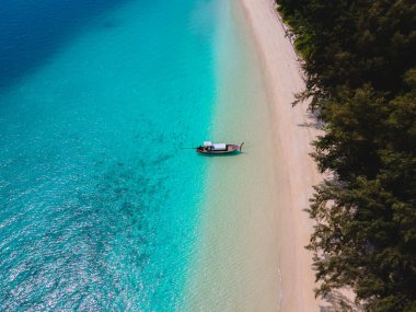 Beyaz tropikal plajı ve turkuaz renkli okyanusu olan Koh Kradan Adası. Kumsaldaki uzun kuyruklu hava aracı görüntüsü.