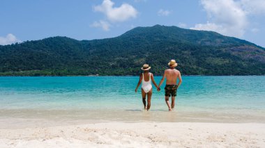 Koh Lipe Adası Tayland sahilinde iki kadın ve erkek. Mavi okyanusu ve beyaz yumuşak kumları olan tropik bir ada. Ko Lipe Adası Tayland