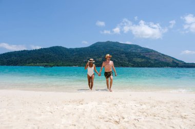 Koh Lipe Adası Tayland sahilinde iki kadın ve erkek. Mavi okyanusu ve beyaz yumuşak kumları olan tropik bir ada. Ko Lipe Adası Tayland