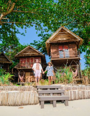 Tayland 'da bir adanın sahilinde bungalov, plajda ahşap bir villa, palmiye ağaçları, Tayland' da tatilde bir çift.