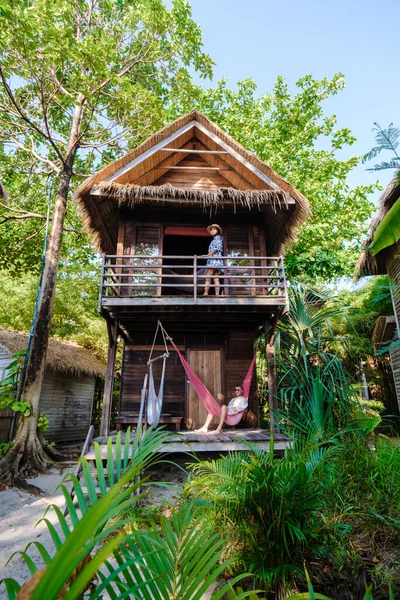 タイの島のビーチにあるバンガロー ヤシの木があるビーチにある木造ヴィラ タイでの休暇中のカップル — ストック写真