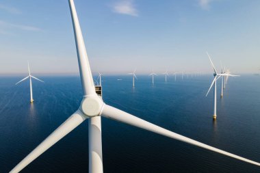 Mavi gökyüzü olan yel değirmeni parkı, okyanusta türbinler.. 