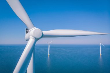 Hollanda okyanusunda mavi gökyüzü olan Windmill Parkı 'ndaki hava aracı görüntüsü Hollanda' nın en büyük rüzgar parkı olan yeşil enerji üretiyor. 