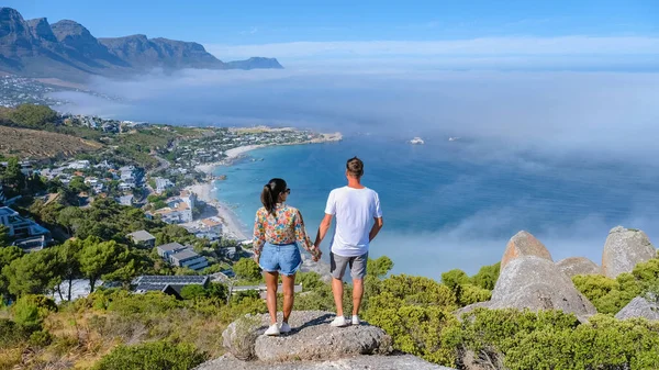 在开普敦坎普斯湾的岩石观景处 可以看到坎普斯湾上空的雾气覆盖着大海 来自南非开普敦海洋的浓雾 男人和女人都站在不同的立场上 — 图库照片