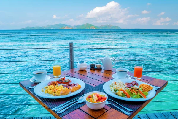 晴れた日にラ ディジェ セイシェル熱帯島の海を見下ろすプールでビーチでの朝食 — ストック写真