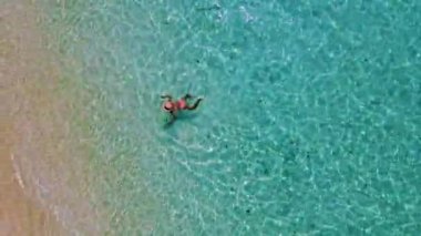 Tayland 'da güneşli bir günde, Güney Tayland' da Koh Kradan Adası 'nda okyanusta yüzen Asyalı kadınlar ve turkuaz renkli bir okyanus.