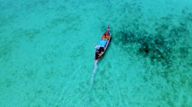 Turkuaz 'daki uzun kuyruklu tekneler güneşli bir günde Güney Tayland' daki Koh Kradan Adası 'nda okyanus renklerine büründü. 
