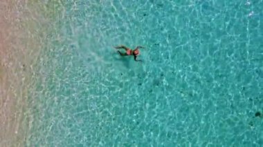 Tayland 'da güneşli bir günde, Güney Tayland' da Koh Kradan Adası 'nda okyanusta yüzen Asyalı kadınlar ve turkuaz renkli bir okyanus.