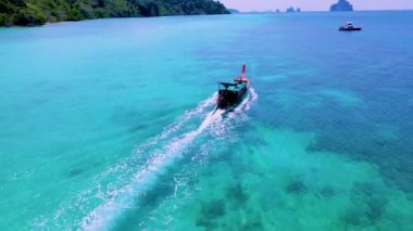 Turkuaz 'daki uzun kuyruklu tekneler güneşli bir günde Güney Tayland' daki Koh Kradan Adası 'nda okyanus renklerine büründü. 