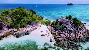Koh Lipe Adası yakınlarındaki küçük bir tropikal adada kanoyla gezen bir çift kadın ve erkek Satun Tayland 'da.
