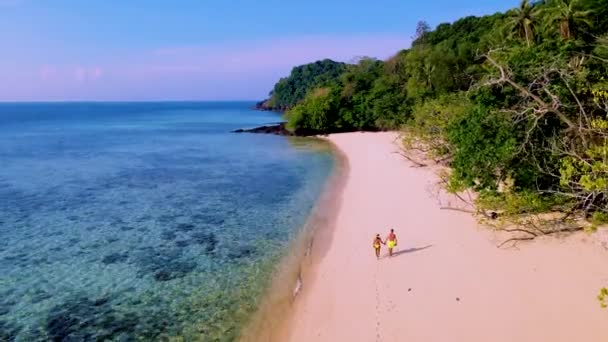 在日落时分 一群男人和女人在沙滩上散步 在阳光灿烂的日子里 泰国Koh Kradan岛 绿松石色的大海映衬着他们 — 图库视频影像