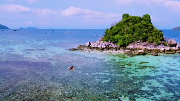 コリペ島の近くの小さな熱帯の島でカヤックを持つ男女のカップル Satun Thailand熱帯のビーチとターコイズブルーの海が晴れた日に — ストック動画