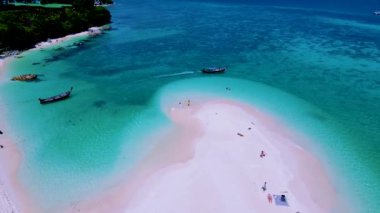 Kuzey sahilinde Koh Lipe Adası Satun Tayland 'da bir kumsal barı. Ko Lipe 'in mavi okyanusunda kumsalda yürüyen bir çift kadın ve erkek.