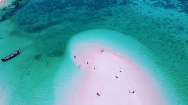 Kuzey sahili, Koh Lipe Adası Satun Tayland 'da tropikal plajı ve turkuaz renkli okyanusu olan bir kumsal. Kumsalda yürüyen bir çift kadın ve erkek.