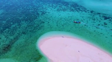 Kuzey sahili, Koh Lipe Adası Satun Tayland 'da tropikal plajı ve turkuaz renkli okyanusu olan bir kumsal. Ko Lipe 'in mavi okyanusunda kumsalda yürüyen bir çift kadın ve erkek.