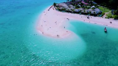 Kuzey sahili, Koh Lipe Adası Satun Tayland 'da tropikal plajı ve turkuaz renkli okyanusu olan bir kumsal. Kumsalda yürüyen bir çift kadın ve erkek.