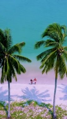 Koh Mook Adası ya da Koh Muk Trat Tayland palmiye ağaçları olan tropikal beyaz bir plaj. Tayland 'da tatilde olan bir çift adam ve kadın sahilde yürüyorlar.