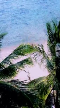 Kumsalda güneşli bir günde turkuaz renkli bir okyanusla Koh Kradan Adası sahilinde bir çift kadın ve erkek.