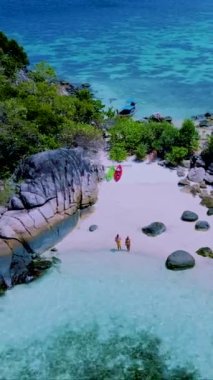 Koh Lipe Adası yakınlarındaki küçük bir tropikal adada kanoyla gezen bir çift kadın ve erkek Satun Tayland 'da.