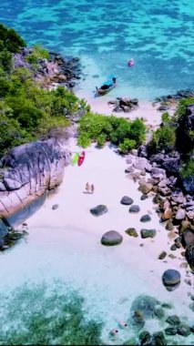 Koh Lipe Adası yakınlarındaki küçük bir tropikal adada kanoyla gezen bir çift kadın ve erkek Satun Tayland 'da.
