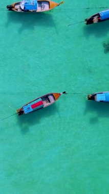 Koh Lipe Adası Satun Tayland. Tropikal bir plajı ve turkuaz renkli okyanusu var. Güneşli bir günde kumsalda uzun kuyruklu tekneleri var.