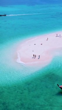 Koh Lipe Adası Satun Tayland 'daki kumsalda tropikal bir plaj ve turkuaz renkli bir okyanus. Tatil sırasında Ko Lipe 'nin mavi okyanusunda bir kumsalda yürüyen bir çift kadın ve erkek.