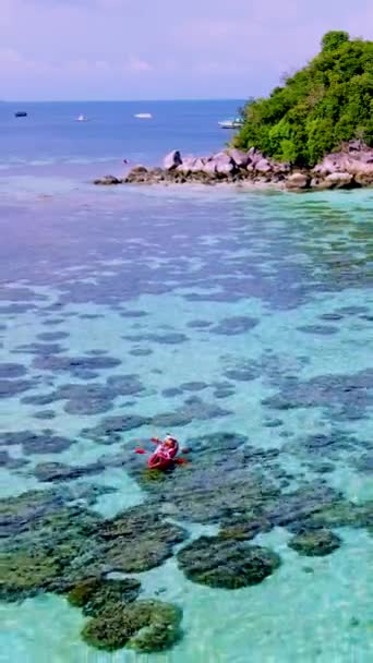 在一个阳光明媚的日子里 一对夫妇带着皮划艇在靠近泰国佐敦的一个热带小岛上 那里有热带海滩和草屋色的大海 — 图库视频影像