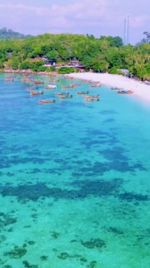 Koh Lipe Adası, Satun Tayland. Tropikal bir plajı ve turkuaz renkli okyanusu var. Sabahları kumsalda renkli uzun kuyruklu tekneleri var.