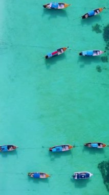 Koh Lipe Adası Satun Tayland. Tropikal bir plajı ve turkuaz renkli okyanusu var. Güneşli bir günde kumsalda uzun kuyruklu tekneleri var.