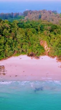 Tayland 'da güneşli bir günde, Tayland' ın Koh Kradan Adası sahilinde turkuaz renkli bir okyanusu olan bir çift kadın ve erkek.