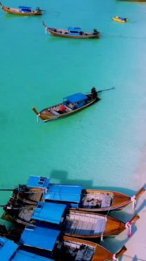 Koh Lipe Adası Satun Tayland. Tropikal bir plajı ve turkuaz renkli okyanusu var. Güneşli bir günde kumsalda uzun kuyruklu tekneleri var.