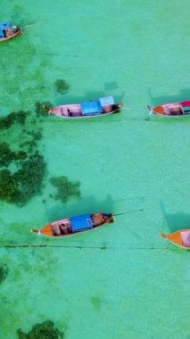Koh Lipe Adası, Satun Tayland. Tropikal bir plajı ve turkuaz renkli okyanusu var. Ko Lipe sahilinde uzun kuyruklu tekneleri var.