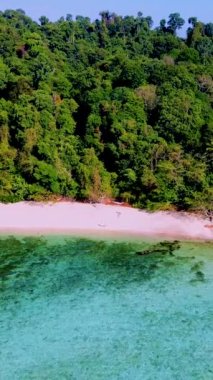 Tayland 'da güneşli bir günde, Tayland' ın Koh Kradan Adası sahilinde turkuaz renkli bir okyanusu olan bir çift kadın ve erkek.