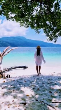 Koh Lipe Tayland 'da tatilde olan kadınlar yazın güneşli bir günde Koh Lipe Tayland' ın mercan kayalıklarında bir kumsalda yürüyorlar.