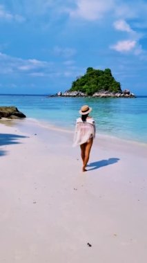 Koh Lipe Tayland 'da tatilde olan kadınlar yazın güneşli bir günde Koh Lipe Tayland' ın mercan kayalıklarında bir kumsalda yürüyorlar.
