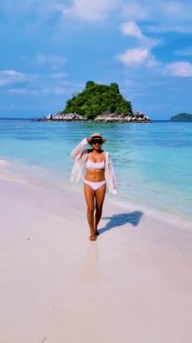 Koh Lipe Tayland 'da tatilde olan kadınlar yazın güneşli bir günde Koh Lipe Tayland' ın mercan kayalıklarında bir kumsalda yürüyorlar.