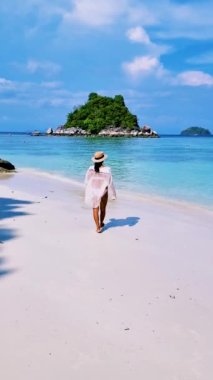Koh Lipe Tayland 'da tatilde olan kadınlar yazın güneşli bir günde Koh Lipe Tayland' ın mercan kayalıklarında bir kumsalda yürüyorlar.