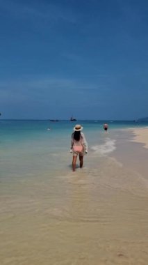 Railay Beach Krabi Tayland 'da yürüyen kadınlar, plajda gezen Railay Krabi' nin tropikal plajı, Tayland 'da geleneksel uzun bir teknesi olan huzurlu Railay Railay Plajı manzarası.. 