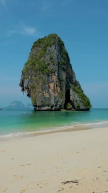 Railay Plajı Krabi Tayland, Tayland 'da geleneksel uzun teknesi ve bulutlu gökyüzü olan huzurlu Railay Krabi' nin tropikal plajı.