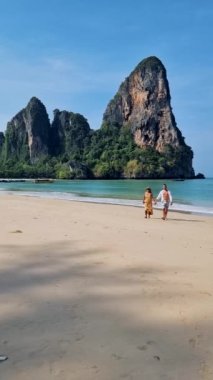 Railay Beach Krabi Tayland, Railay Krabi 'nin tropikal plajı, kumsalda bir çift kadın ve erkek., 