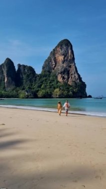 Railay Beach Krabi Tayland, Railay Krabi 'nin tropikal plajı, kumsalda bir çift kadın ve erkek., 