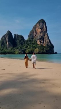 Railay Beach Krabi Tayland, Railay Krabi 'nin tropikal plajı, kumsalda bir çift kadın ve erkek., 