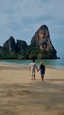 Railay Beach Krabi Tayland, Railay Krabi 'nin tropikal plajı, plajda bir çift kadın ve erkek, Tayland' da huzurlu bir Railay Sahili manzarası. 