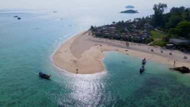 Koh Lipe Tayland 'da tatilde olan bir çift erkek ve kadın güneşli bir günde Koh Lipe' nin mercan kayalığındaki bir kumsalda yürüyorlar.